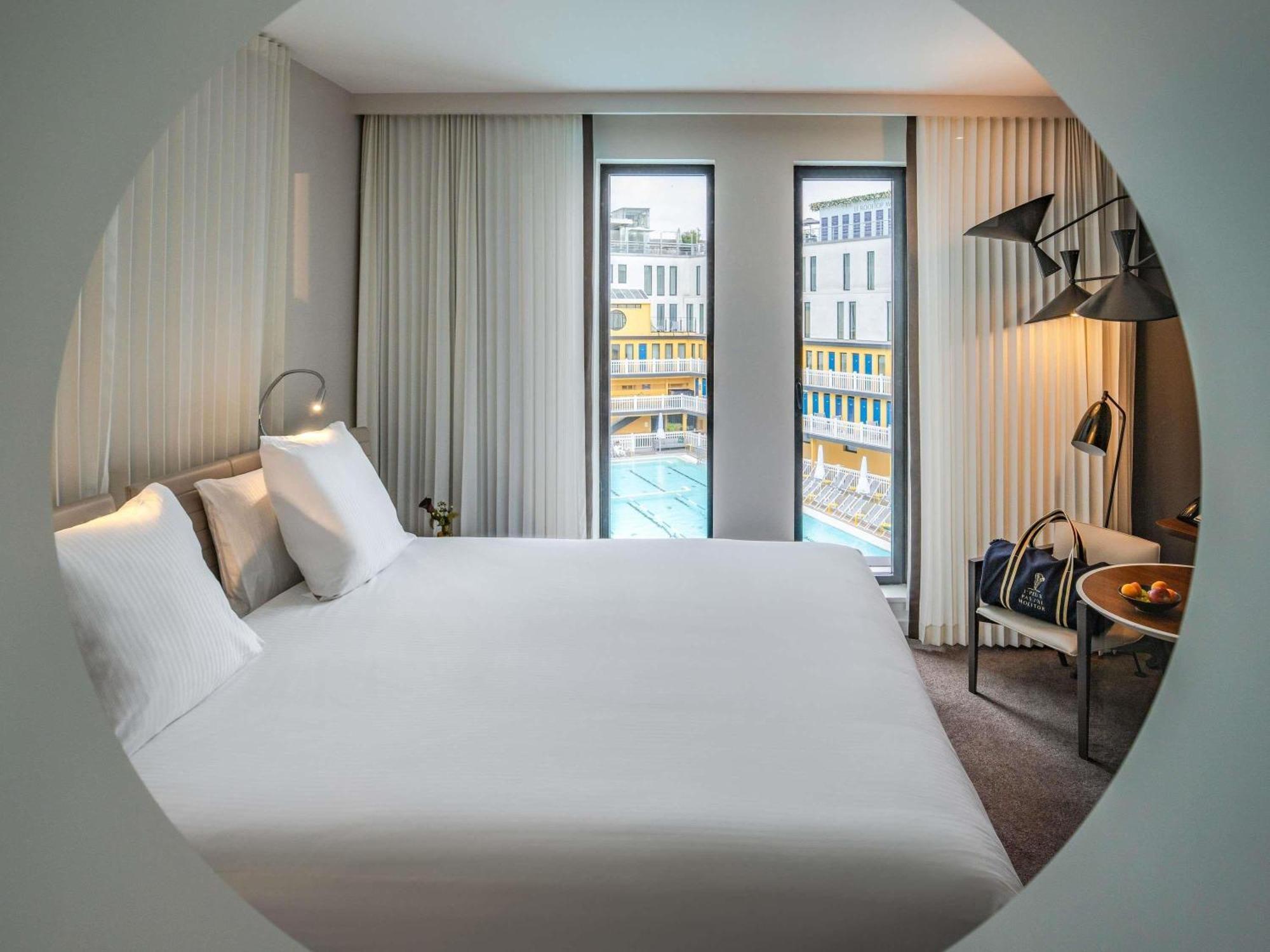 Suite mit Kingsize-Bett, Schlafsofa, Wohnbereich und Poolblick
